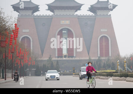 A cyclist wearing face mask against air pollution rides on a road in heavy smog in Taiyuan city, north China's Shanxi province, 26 February 2019. Stock Photo