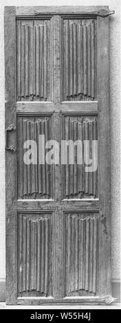 Door, through a partially profiled window divided into three pairs of standing rectangular panels with letter filling, Door of oak, through a partially profiled window divided into three pairs of standing rectangular panels with letter filling. A handle with twisted articulation and rosettes attached to the left-hand style and two handles on the upper and lower sill are made of forged iron., anonymous, Netherlands, c. 1500 - c. 1550, wood (plant material), oak (wood), iron (metal), h 179 cm × w 66.5 cm × d 5.5 cm Stock Photo