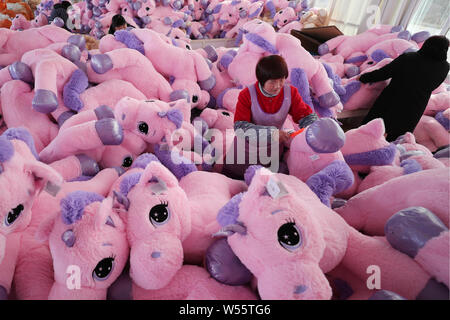 Chinese workers make stuffed toys at a toy factory in Lianyungang city, east China's Jiangsu province, 21 February 2019.   China has posted a surprise Stock Photo