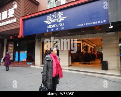 --FILE--Pedestrians walk past a store of Bosideng International Holdings Ltd in Shanghai, China, 11 December 2018.    Bosideng International Holdings Stock Photo