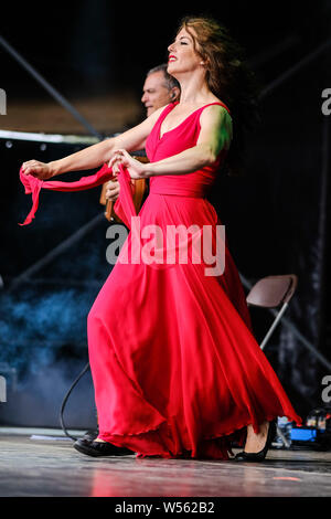 Malmesbury, Wiltshire, UK. 26th July 2019. CGS Canzoniere Grecanico Salentino performs on the Open Air Stage WOMAD Festival (World of Music Arts and Dance) on Friday 26 July 2019 at Charlton Park, Malmesbury. Pictured: Silvia Perrone, dance. Picture by Julie Edwards. Credit: Julie Edwards/Alamy Live News Stock Photo