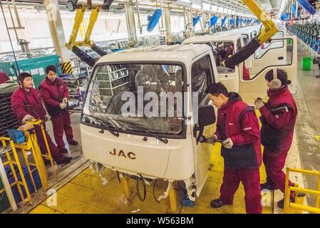 --FILE--Chinese workers assemble trucks on the assembly line at a ...