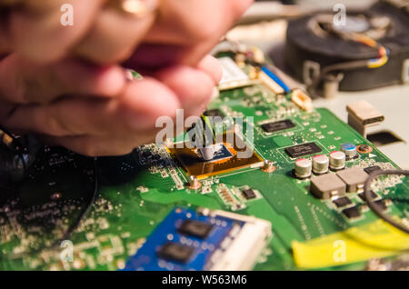 Technical support worker greases with thermal grease paste computer processor Stock Photo
