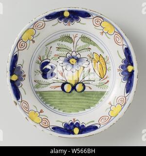 Plate of multicolored painted faience, decorated with flowers in blue, yellow, green, red and purple on white ground., anonymous, Delft, 1750 - 1790, d 23.2 cm × h 3.7 cm Stock Photo