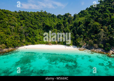 Aerial drone view of a tropical beach on a green, deserted island Stock Photo