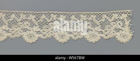 Strip of spool lace with scalloped edge of alternately a rosette flower and a five-lobed leaf, Strip of natural spool lace, Cluny lace. The repeating pattern consists of a rosette flower and a slanting five-lobed leaf along the underside of the strip. The consecutive flowers and leaves are placed against each other and together form a scallop edge. Above the center line a kind of zigzag line has been created with obliquely placed elongated motifs, each crowned by three oval motifs. The motifs are made in loosely worked linen with double contour threads. They are connected to each other by a Stock Photo
