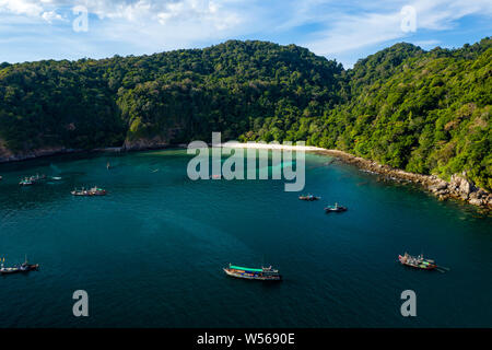 Aerial drone view of traditional longtail fishing boats in a bay on a small, tropical island (Cavern Island, Mergui, Myanmar) Stock Photo