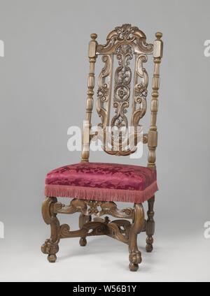 Chair with angled front legs, X-shaped cross, upholstered with flower pattern, Walnut chair, covered in bronze-colored pressed fabric flower pattern. The chair has angled front legs in the shape of broken S-volutes and rests on lion's claws that include spheres. The X-shaped cross has broken S-volutes, as well as the front cover. There is a button at the intersection. The high, open-worked back also shows S-volutes. The elongated center piece is decorated with circle and rosette in the middle and above and below with acanthus leaves and rosettes., anonymous, Netherlands, 1685 - 1700, walnut Stock Photo