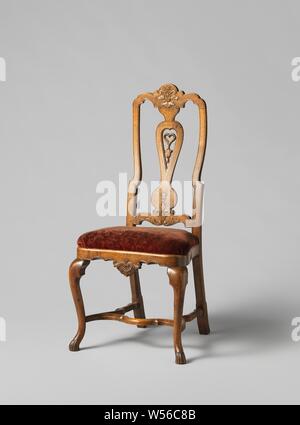 Chair with S-shaped angled front legs and scalloped parts. Shell and acanthus leaf decoration. Loose seat upholstered in floral velvet, Chair made of walnut. the furniture has a loose, velvet cushioned pillow mounted on a window. It rests on angled S-shaped front legs. The H-shaped cross is scalloped, just like the front line, which has a shell motif in the middle. The high back is slightly horizontal and has an open center leaf with a heart for decoration and scalloped outline. The window is profiled and has styles and a scalloped top and bottom sill with acanthus leaf in the middle Stock Photo