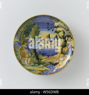 Dish with Metabus Throwing Camilla across the River Amasenus Dish with Metabus throwing Camilla over the Amasenus river, Round dish on a base of multi-colored majolica. Depicted is Metabus who throws Camilla over the Amasenus River, derived from the Aeneas of Virgil. On the left bank of the Amasenus, Metabus has a spear in his hands, to which Camilla is tied with a cloth. With this he reaches to the other bank, on which three women are standing. There is a river god in the water. On the back of the board the inscription: Methapo oltr Amasce // lancio Camilla // 1544, Metabus, Camilla's father Stock Photo