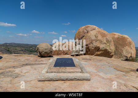 A full-size plaque over a stone marking the last resting place of Cecil John Rhodes on top of World's View in front of a collection of boulders. Stock Photo