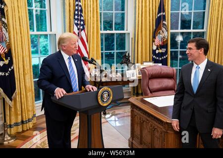 U.S President Donald Trump, left, delivers remarks following the swearing ceremony for Secretary of Defense Mark Esper, right, in the Oval Office of the White House July 23, 2019 in Washington, DC. Stock Photo