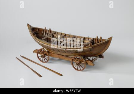 Model of a lifeboat on a wagon, Model of a Lifeboat on a Cart, Technical model. Over-seam pointed sloop, rounded with kim keels, the sheer rising sharply at both ends. Double belts: twelve rowing rolls for five dulls, which are connected by a plank placed alongside the ship, front and back. Silk covers, filled with cork at the bottom, against the doftweigher. A thick layer of cork in brass bands has been applied to the outside of the dolboard as a propellant, while four bollards have been applied to the dolboard. A steering belt and a normal oar. Only the frame with axles for the missing Stock Photo