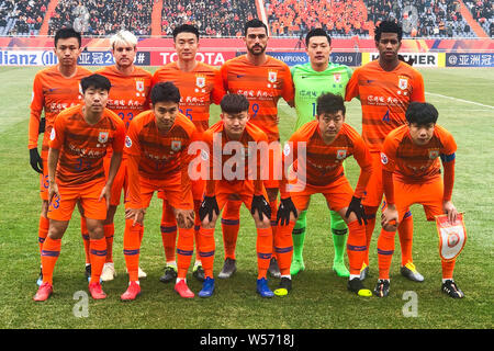 Players of the starting line-up of China's Shandong Luneng Taishan F.C. pose for photos before their qualifying match against Vietnam's Hanoi FC durin Stock Photo