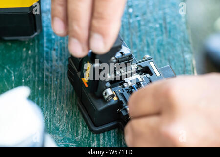 Device for mounting optical cable. Optical internet Technology concept. Optical fiber assembly. Stock Photo