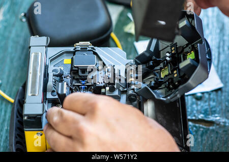 Device for mounting optical cable. Optical internet Technology concept. Optical fiber assembly. Stock Photo