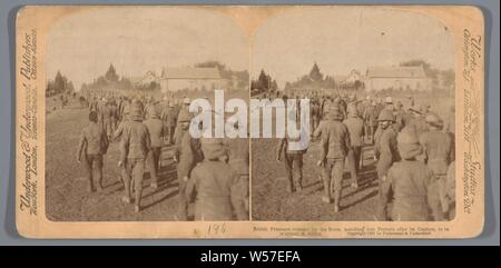 Staged show of British soldiers captured and released during the Second Boer War at Pretoria, British Prisoners released by the Boers, marching into Pretoria after its Capture, to be re-armed, S Africa (title on object), the soldier, the soldier's life, prisoner of war (after the battle), Pretoria, Underwood and Underwood (mentioned on object), 1901, photographic paper, cardboard, h 88 mm × w 178 mm Stock Photo