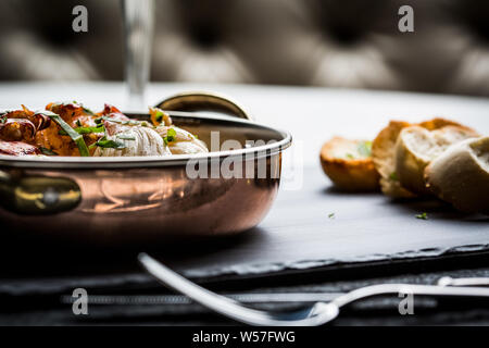 Beautiful giant lobster loin with sauce and coriander accompanied by bread slices. Stock Photo