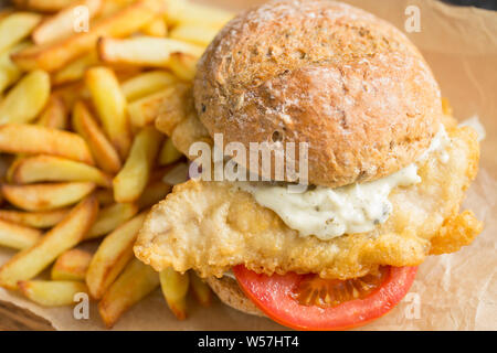 Two fillets of mackerel, Scomber scombrus, that have been dipped in flour and batter and deep fried to make a homemade mackerel burger. The mackerel w Stock Photo