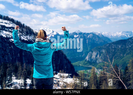 Beautiful young girl on the top of the mountain showing a winning gesture. Motivational theme Stock Photo