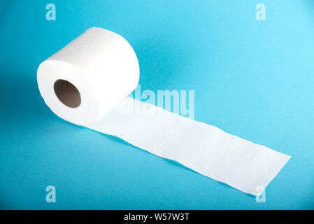 A roll of white toilet paper on a colored background. Stock Photo