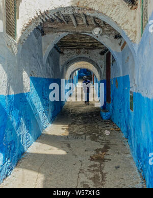 Tetuan, Morocco, Africa - February 15, 2016: Passage in the medina of Tetuan, with a pedestrian on his back walking in the passage