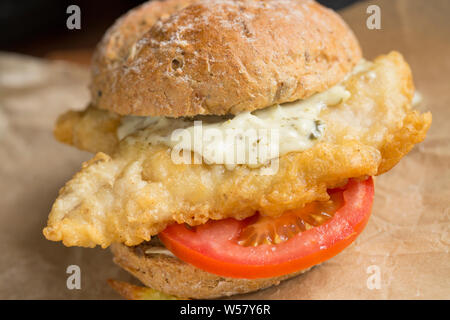 Two fillets of mackerel, Scomber scombrus, that have been dipped in flour and batter and deep fried to make a homemade mackerel burger. The mackerel w Stock Photo