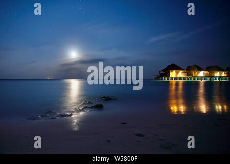 Beautiful sunset, Dark with the moon shinning on the smooth surface of the sea and rocks in Kandolhu island Maldives 2019 Stock Photo