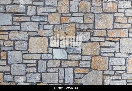 Grey stone wall with interesting texture of stones. Vintage background of grey wall. Stock Photo
