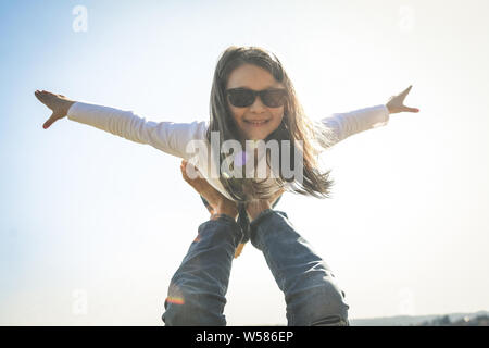 I believe i can fly, low angle view of image with one parent, strong father supports his excited daughter making plane yelling having a lot of safety, Stock Photo