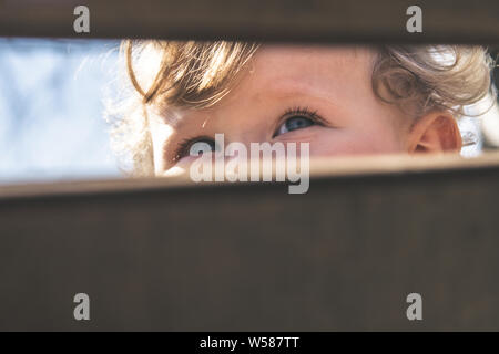 Baby blue eyes closeup. Baby, kid, sight, concentration, eye health, curiosity discovery and exploration concept. Image detail look of nice blonde cur Stock Photo