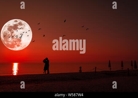 Silhouette of a kissing couple under full moon at night Stock Photo - Alamy