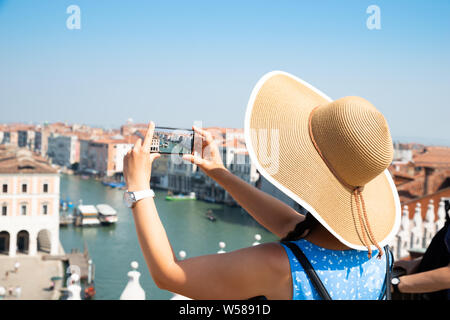 Rear View Of A Female With Smart Phone Takes Pictures In Venice Italy Stock Photo