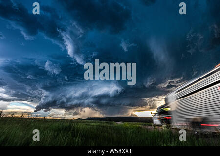 Moving truck heading toward a huge storm and cloud sky Stock Photo