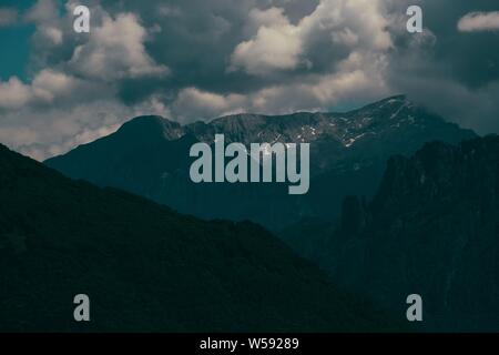 Beautiful shot of forested mountains with cloudy sky Stock Photo