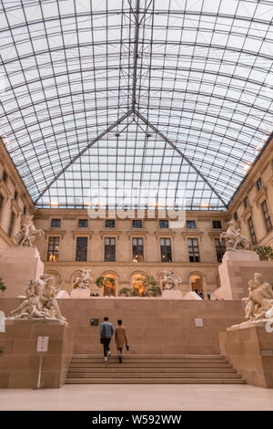 Great picture of the sculpture garden known as Cour Marly in the Richelieu wing of the Louvre Museum. Two visitors are going up the stairs of the... Stock Photo