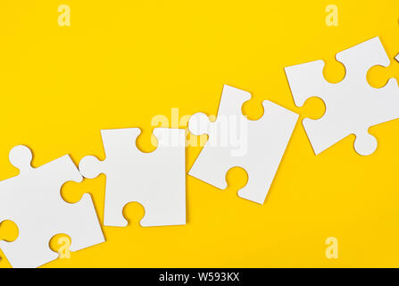 blank white big puzzles on yellow background, flat lay Stock Photo