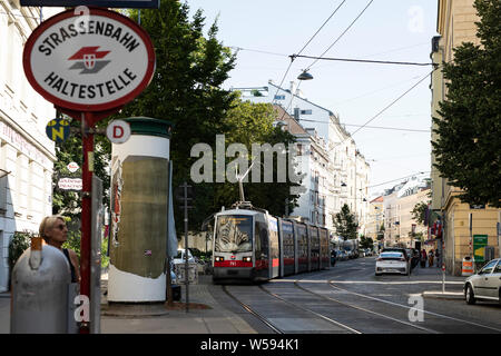 A tram arrives at a stop on Porzellangasse in the Alsergrund neighborhood of Vienna, Austria. Stock Photo