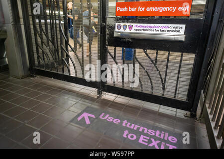 Decals in the West 42nd Street-Times Square street subway station in New York on Thursday, July 25, 2019 direct commuters to use the turnstiles to exit and not the emergency gates which allows fare evaders to enter. Fare evasion has been a drain on MTA revenue after the NYPD eased enforcement, issuing summonses as opposed to arrests, and the Manhattan District Attorney's office stopped prosecuting most cases. (© Richard B. Levine) Stock Photo