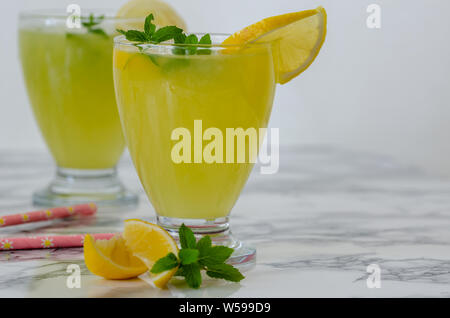 Refreshing drinks for summer, cold sweet and sour lemonade juice  in the glasses garnished with sliced fresh lemons Stock Photo