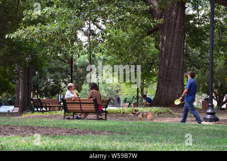 A couple sits on a park bench in Nash Square in downtown Raleigh North Carolina. Stock Photo