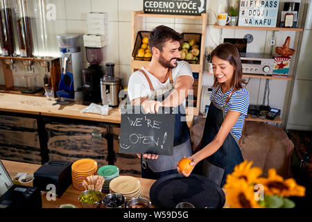 Happy owner of a cafe showing open sign. Stock Photo