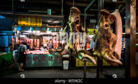 Raw pig face hanging on a hook. Traditional taiwanese food selding in a shop located at market of Taipei. Sale on market. Popular famous marketplace Stock Photo