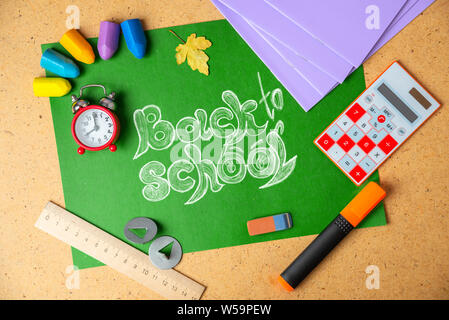 Back to school concept. School supplies on green board. Stock Photo
