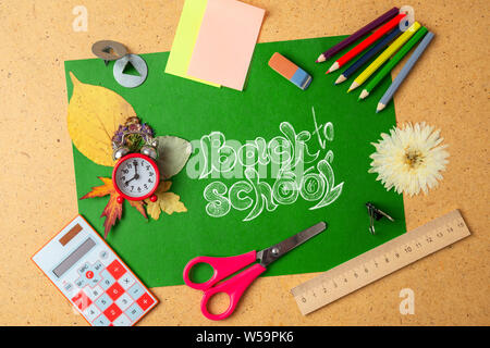 Back to school concept. School supplies on green board. Stock Photo