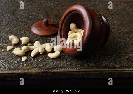 Cashews in wooden utensils on a beautiful vintage table Stock Photo