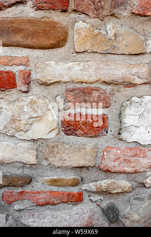 Typical wall of ancient Italian house made of hand-carved stones and bricks Stock Photo