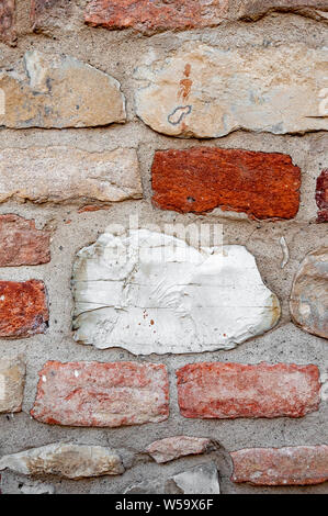 Typical wall of ancient Italian house made of hand-carved stones and bricks Stock Photo