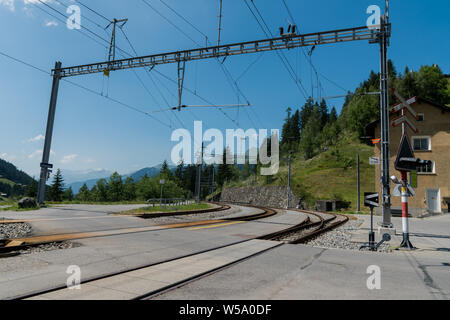 Langwies, GR / Switzerland - 24. July, 2019: railroad track and crossing at the train station in Langwies in Switzerland Stock Photo