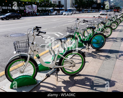 Seoul, South Korea - June 3, 2017: Bright green bicycles parked on the sidewalk in downtown in Seoul. Stock Photo